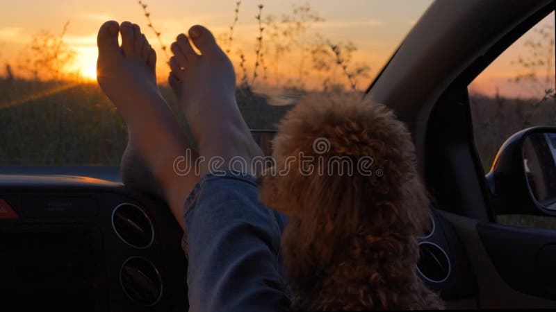 Woman feet on car dashboard.